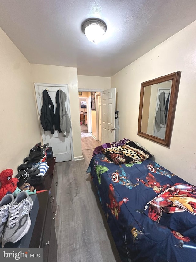 bedroom featuring hardwood / wood-style flooring, a textured ceiling, and a closet