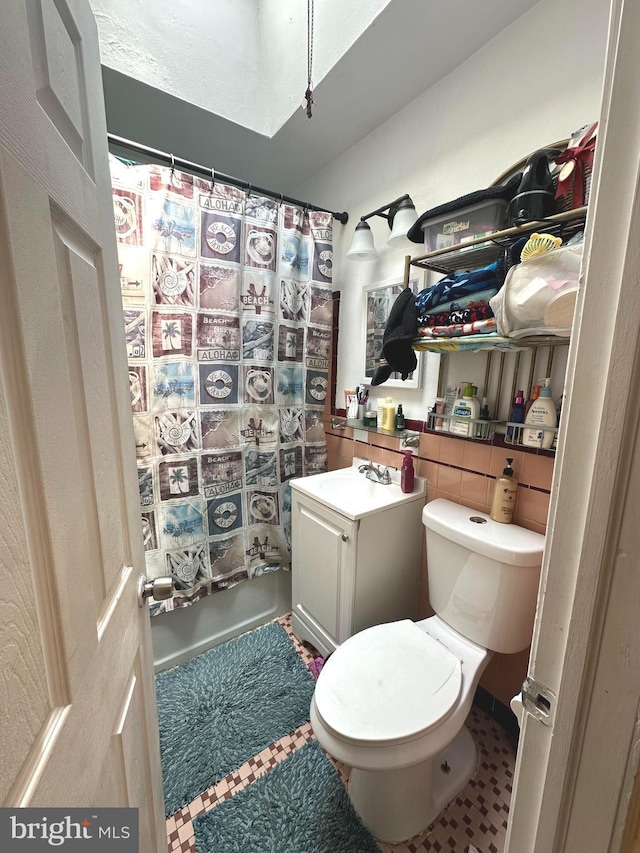 bathroom featuring a shower with curtain, vanity, and toilet