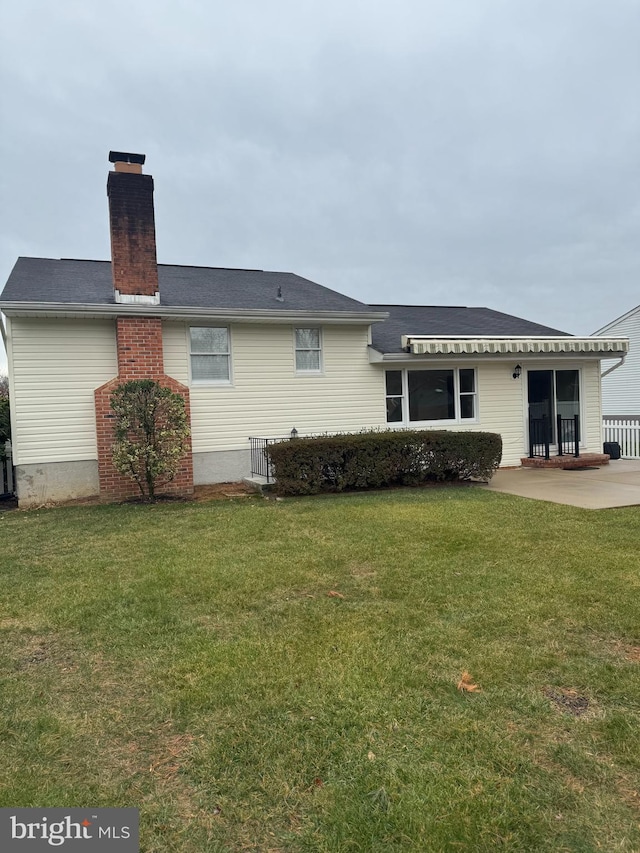 rear view of house featuring a yard and a patio area