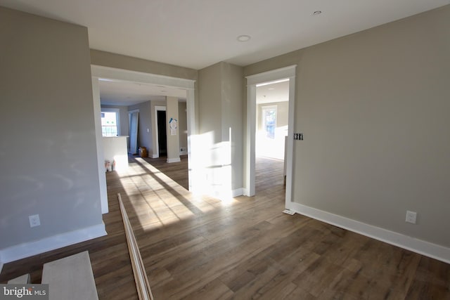 spare room with dark hardwood / wood-style flooring and a wealth of natural light