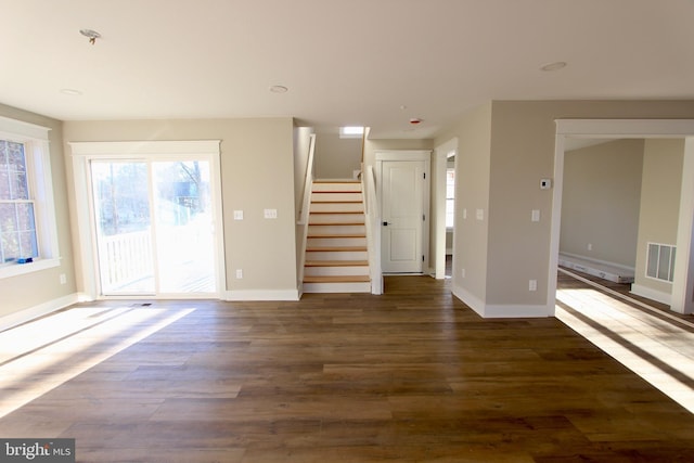 unfurnished living room with dark wood-type flooring