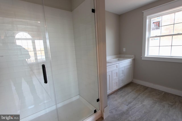 bathroom with wood-type flooring, vanity, and walk in shower