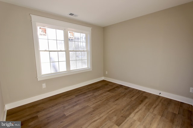 unfurnished room with dark wood-type flooring