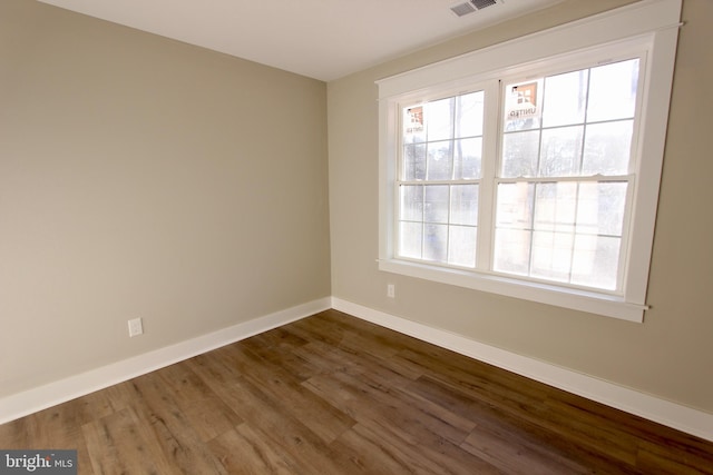 unfurnished room with dark hardwood / wood-style flooring