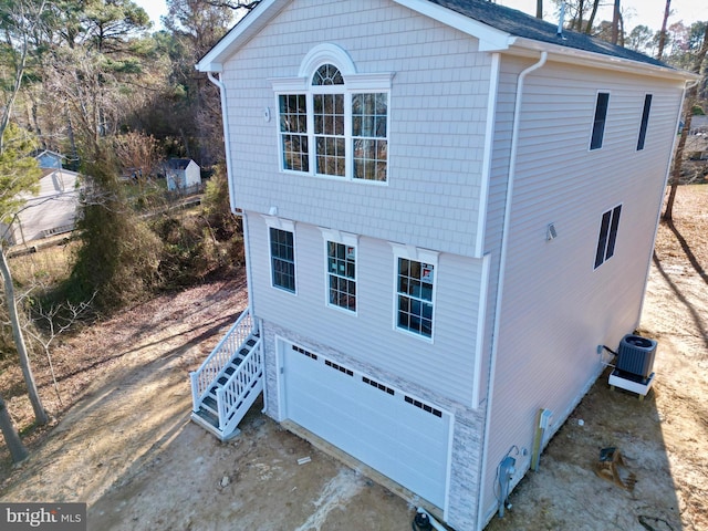 view of side of home featuring a garage and central air condition unit