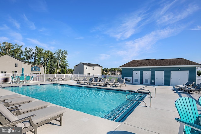 view of swimming pool featuring a patio area and an outbuilding