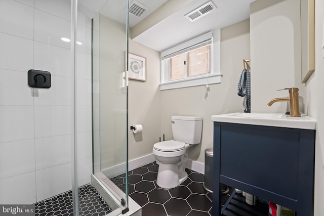 bathroom with vanity, toilet, and a shower with shower door