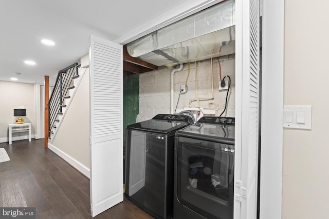 clothes washing area with dark hardwood / wood-style floors and independent washer and dryer