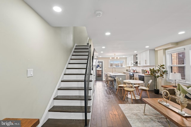 staircase with hardwood / wood-style floors, plenty of natural light, and sink