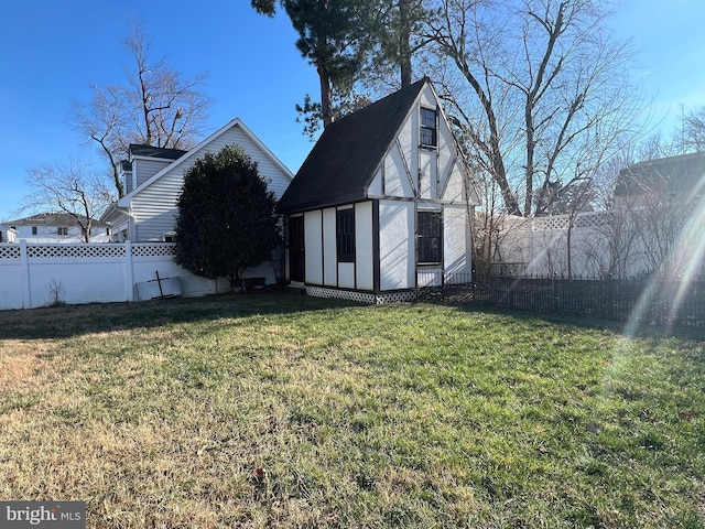 rear view of house featuring an outbuilding and a lawn