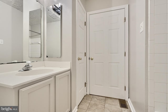 bathroom featuring vanity, a textured ceiling, and tile patterned floors