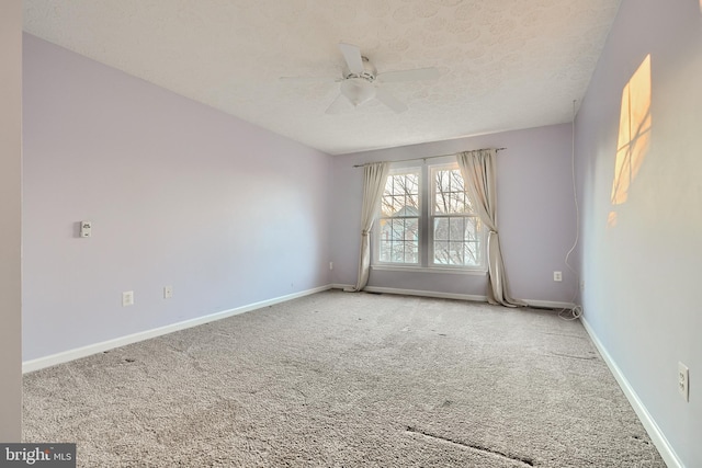 empty room with ceiling fan, carpet floors, and a textured ceiling