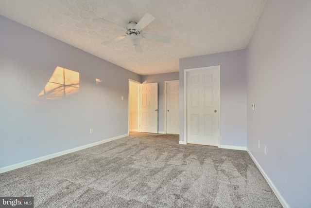 unfurnished bedroom with ceiling fan, carpet, and a textured ceiling