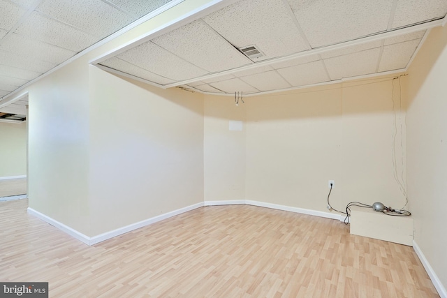 basement with hardwood / wood-style floors and a drop ceiling