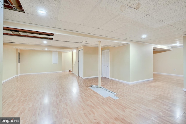 basement with hardwood / wood-style floors and a drop ceiling