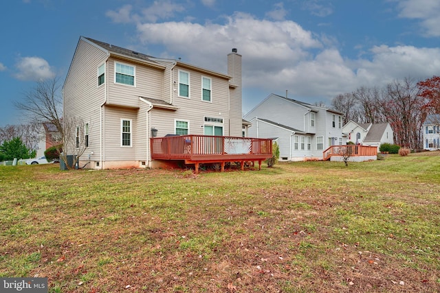 back of property with a deck and a yard