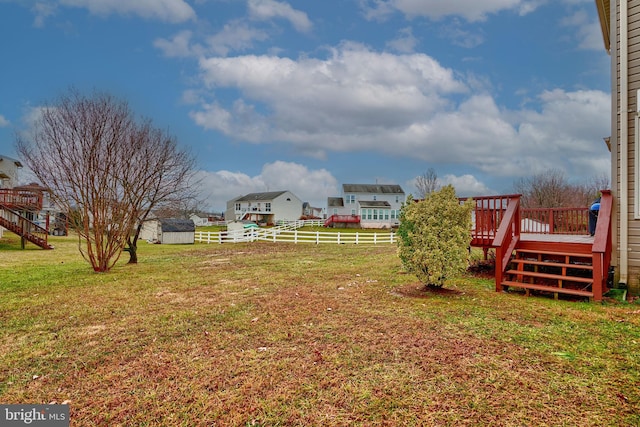 view of yard featuring a wooden deck and a shed