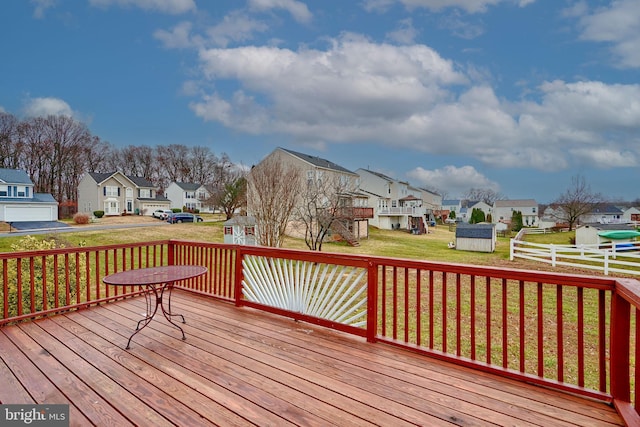 deck featuring a shed and a lawn