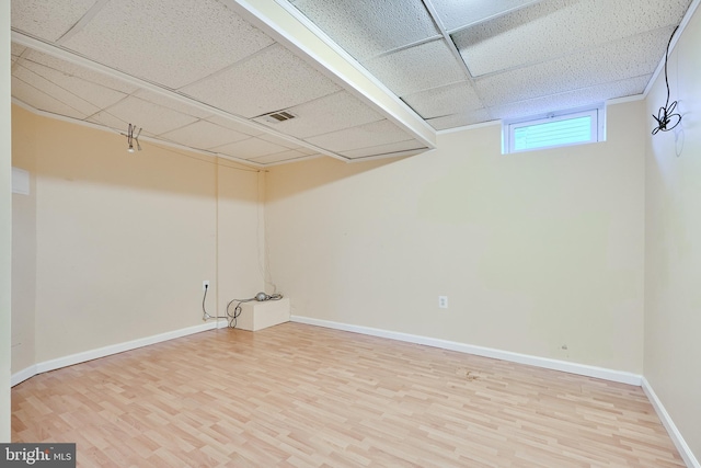 basement with hardwood / wood-style floors and a drop ceiling