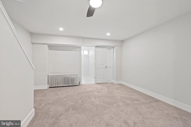 interior space featuring ceiling fan, light colored carpet, and radiator