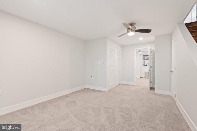 empty room featuring ceiling fan and light colored carpet