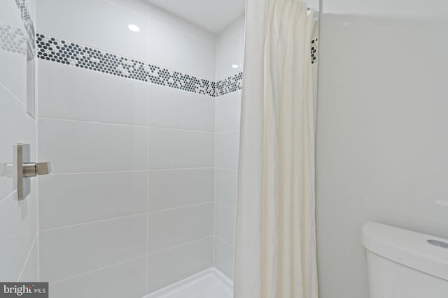 bathroom with a shower with curtain and toilet