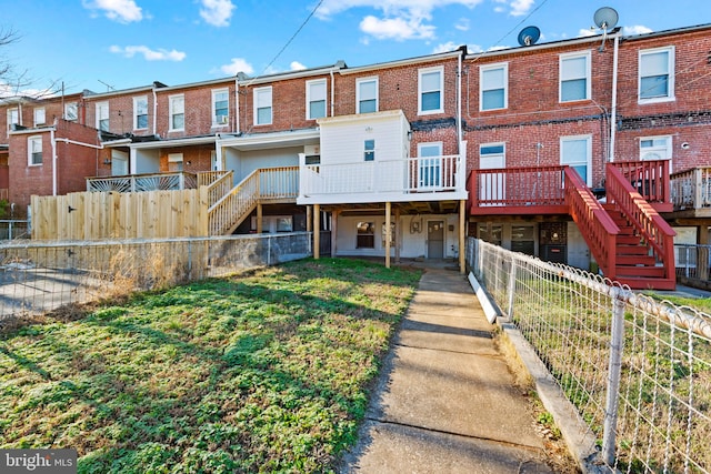 back of house featuring a wooden deck and a yard