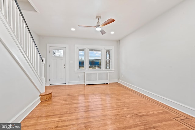 foyer with ceiling fan, radiator heating unit, and light hardwood / wood-style flooring