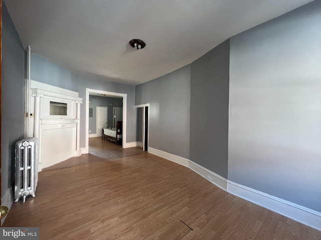 empty room featuring dark wood-type flooring and radiator