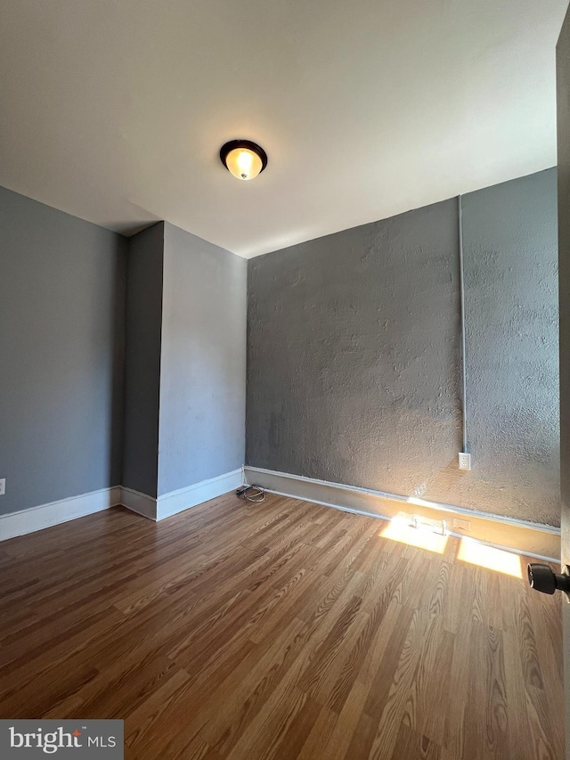 unfurnished room with hardwood / wood-style flooring