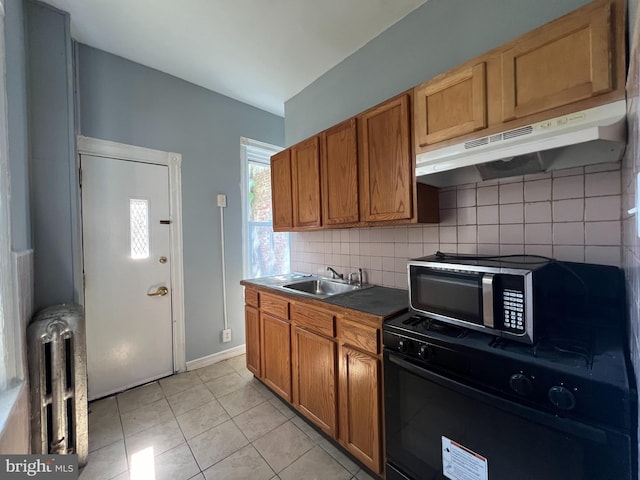 kitchen featuring light tile patterned floors, sink, radiator, and tasteful backsplash