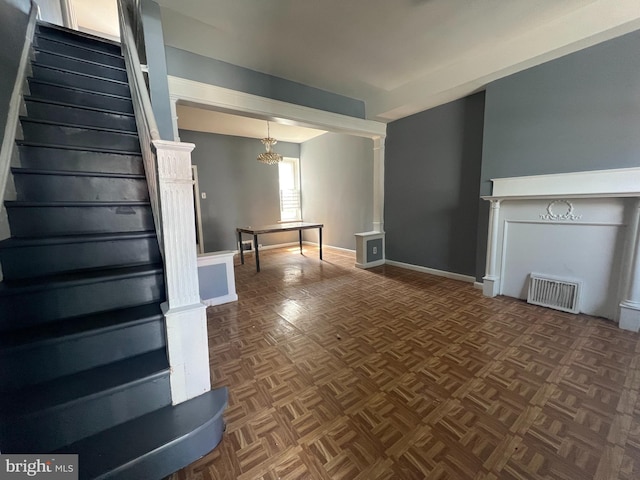 unfurnished living room featuring dark parquet flooring and a notable chandelier