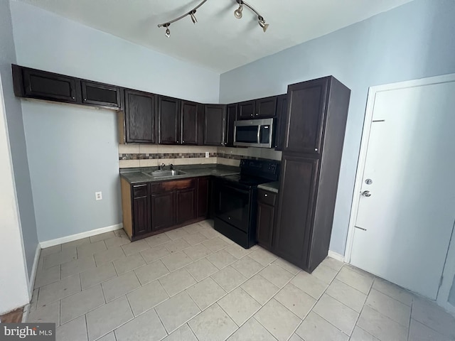 kitchen with black electric range oven, rail lighting, sink, decorative backsplash, and light tile patterned floors