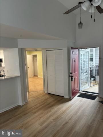 entryway featuring a high ceiling, wood-type flooring, sink, and ceiling fan