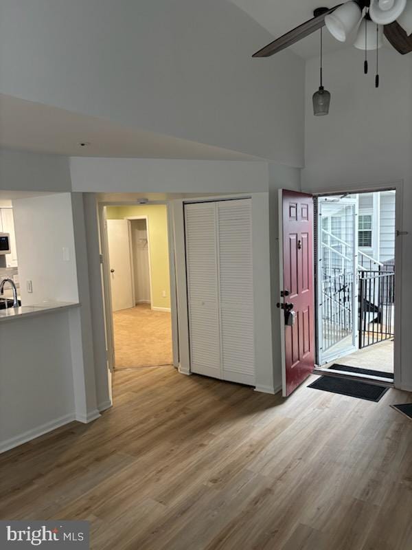 entryway featuring hardwood / wood-style flooring, ceiling fan, sink, and a high ceiling