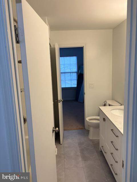 bathroom featuring vanity, tile patterned flooring, and toilet