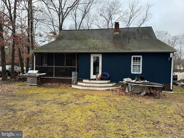 rear view of house with a sunroom and a lawn