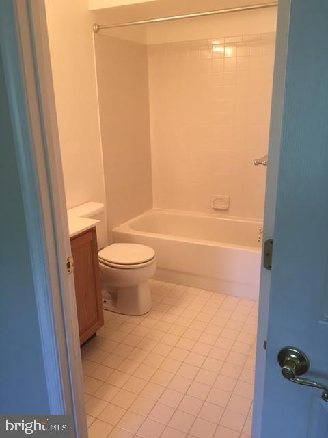 full bathroom featuring tile patterned floors, vanity, toilet, and  shower combination