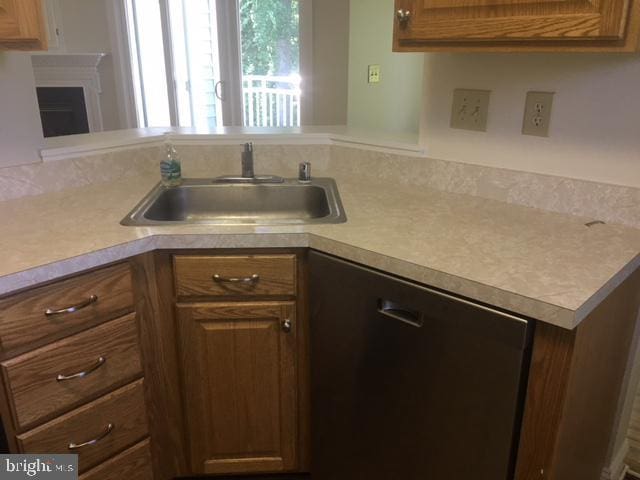 kitchen featuring stainless steel dishwasher, kitchen peninsula, and sink