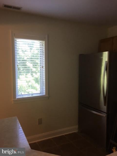 kitchen with tile patterned floors and stainless steel refrigerator