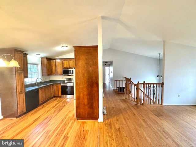 kitchen with stainless steel appliances, hanging light fixtures, lofted ceiling, and light hardwood / wood-style floors