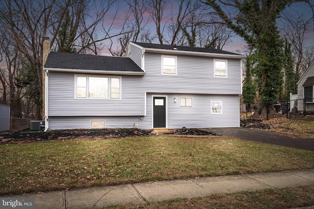 view of front of house featuring a yard and central AC unit