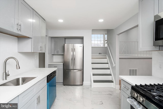 kitchen with tasteful backsplash, gray cabinetry, sink, and appliances with stainless steel finishes