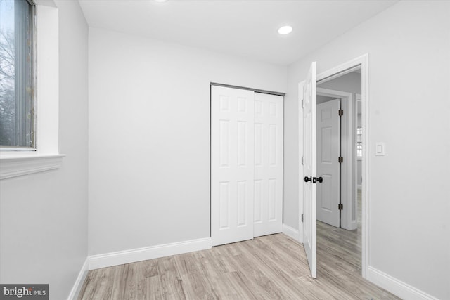 unfurnished bedroom featuring a closet and light wood-type flooring