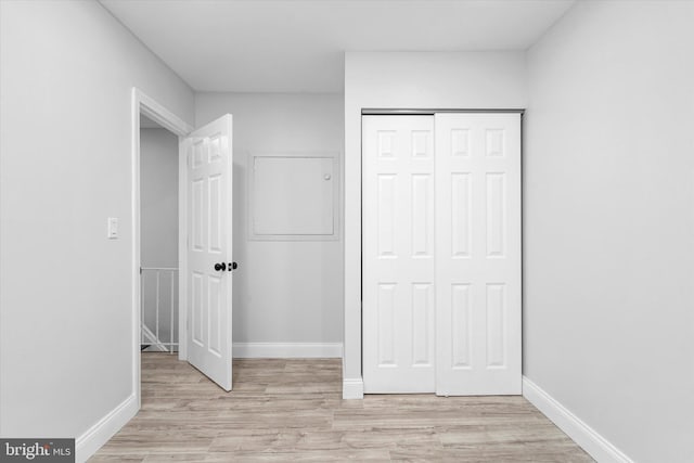 unfurnished bedroom featuring light hardwood / wood-style flooring and a closet