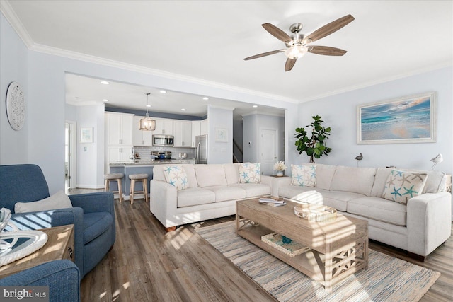 living room featuring ornamental molding, ceiling fan, and dark wood-type flooring