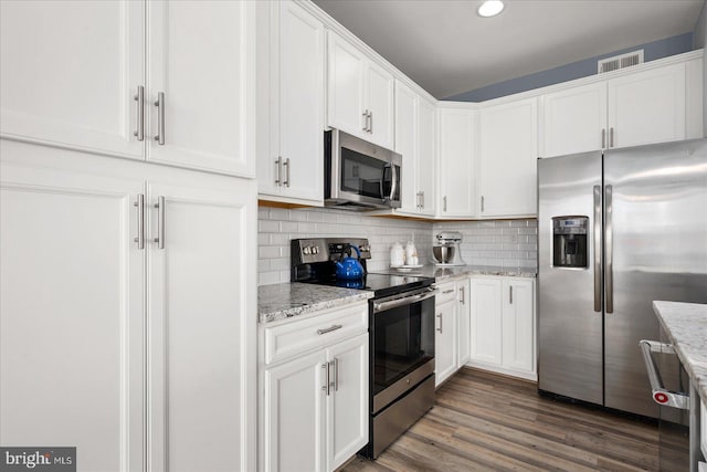 kitchen featuring white cabinets, dark hardwood / wood-style floors, light stone counters, and stainless steel appliances