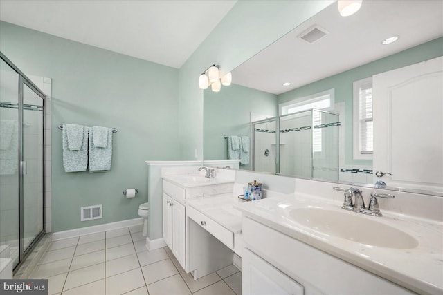 bathroom featuring tile patterned flooring, vanity, toilet, and a shower with door