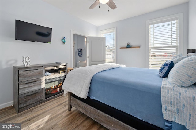 bedroom with hardwood / wood-style floors, connected bathroom, and ceiling fan