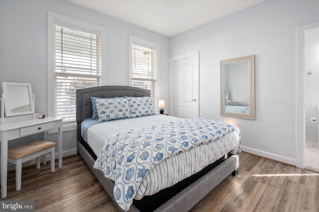 bedroom with multiple windows and dark wood-type flooring